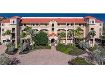 Beautiful Mediterranean-style building with red tile roof, lush landscaping, and inviting entrance at 85 Vivante Blvd # 8542, Punta Gorda, FL 33950