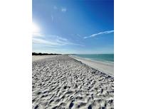 Expansive white sand beach with clear turquoise water and a bright blue sky backdrop at 9400 Little Gasparilla Is # C2, Placida, FL 33946
