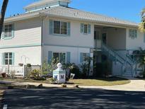 Attractive two-story condo building features pleasing landscaping and calming white and blue trim at 1051 Forrest Nelson Blvd # M 103, Port Charlotte, FL 33952