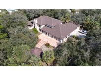 Expansive house with a brown roof, lush trees, and a circular gazebo with a small garden at 1055 & 1075 Yorkshire St St, Port Charlotte, FL 33952