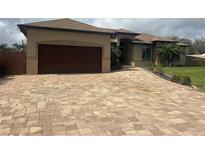 Long driveway with pavers leading to the garage of the house at 2031 Basin St, Port Charlotte, FL 33952