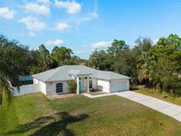 Beautiful single-story home with a well-maintained lawn, mature trees and inviting blue front door at 3213 Belleville Ter, North Port, FL 34286