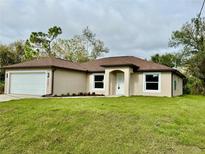 Charming single-story home with a well-manicured lawn, two-car garage and neutral color palette at 3841 Cinderella Rd, North Port, FL 34286