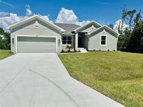 Charming single-story home featuring a well-maintained lawn and a spacious two-car garage at 9590 Little Rock St, Port Charlotte, FL 33981