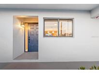 Inviting entrance featuring a blue front door, exterior light fixture, and window with a view into the home at 1356 Rio De Janeiro Ave # 107, Punta Gorda, FL 33983