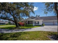 Charming home featuring a lush landscaped front yard with a welcoming two-car garage at 1474 Red Oak Ln, Port Charlotte, FL 33948