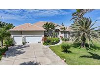 Charming single-story home showcasing a lush lawn, mature trees, and a spacious three-car garage at 16531 San Edmundo Rd, Punta Gorda, FL 33955