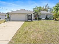 Charming single-story home with a well-manicured lawn and an attached two-car garage at 1702 Rice Ter, North Port, FL 34286