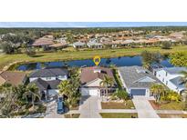 Aerial view of home with large backyard, screened in lanai, and neighborhood pond at 1859 Scarlett Ave, North Port, FL 34289