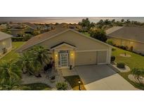 Charming single-story home featuring a well-manicured lawn and inviting front entrance at sunset at 1944 Boddington Trl, Port Charlotte, FL 33980