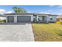 Charming home with a paved driveway leading to a three-car garage and a neatly maintained lawn at 206 Santarem Cir, Punta Gorda, FL 33983