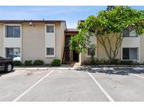 Condo exterior featuring stairs to the units, parking, and green landscaping with a mature tree at 2717 Hidden Lake Blvd # C, Sarasota, FL 34237