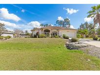 Charming single-story home with a manicured lawn and lush landscaping under a bright blue sky at 3816 N Cranberry Blvd, North Port, FL 34286