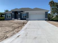 Charming single-story home with a two-car garage and a long concrete driveway at 209 Annapolis Ln, Rotonda West, FL 33947