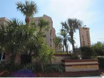View of the exterior with mature landscaping and signage at the East Promenades complex at 21405 Olean Blvd # 605, Port Charlotte, FL 33952