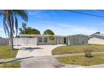 Charming single-story home with a spacious front yard, long driveway, and white privacy fence at 2255 Easy St, Port Charlotte, FL 33952