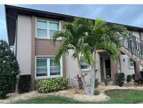 Charming two-story condo with well-maintained landscaping and a decorative palm tree at 25100 Sandhill Blvd # I201, Punta Gorda, FL 33983