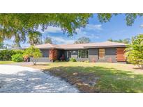 Charming single Gathering home featuring a well-maintained lawn and mature shade trees, and unique architectural details at 4381 Northshore Dr, Punta Gorda, FL 33980