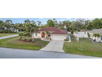 Charming single-story home features a well-maintained lawn, landscaping, and a two-car garage at 23488 Almond Ave, Port Charlotte, FL 33954