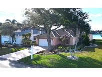 Beautiful home with mature landscaping, a tile roof, and a paver driveway near a lake at 26287 Stillwater Cir, Punta Gorda, FL 33955