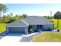 Charming home with a two-car garage, new gray roof, and well-manicured landscaping at 3268 Montgomery Dr, Port Charlotte, FL 33981