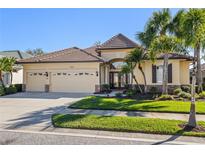 Charming home featuring a three-car garage, tile roof, lush landscaping, and stone accents at 1321 Eagles Flight Way, North Port, FL 34287