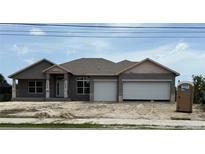 Two-story home with a modern elevation and a two-car garage with green grass and blue skies above at 14735 Keystone Blvd, Port Charlotte, FL 33981