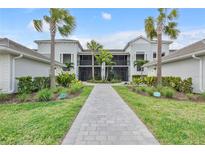 Beautiful building exterior, manicured landscaping, sidewalks, and palm trees at 15970 Grassland Ln # 2816, Punta Gorda, FL 33982