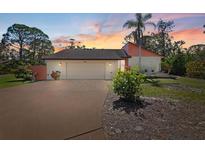 Charming single-Gathering home featuring an attached two car garage and lush landscaping at 1701 Overbrook Rd, Englewood, FL 34223