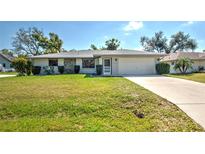 Charming single-story home featuring a well-manicured lawn and an attached two-car garage at 21229 Giddings Ave, Port Charlotte, FL 33952
