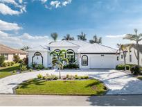 Beautiful single-story home featuring a well-manicured lawn, circular driveway and attached two-car garage at 2181 Via Seville, Punta Gorda, FL 33950