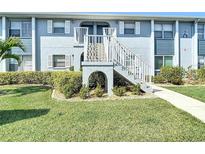 Inviting condo exterior with a well-maintained lawn and staircase leading to the upper units at 25050 Sandhill Blvd # B2 Building 6, Punta Gorda, FL 33983
