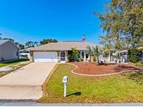 Charming single Gathering home features a well manicured lawn, landscaped garden, and two car garage at 383 Northview St, Port Charlotte, FL 33954