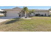 Charming single-story home with a well-manicured lawn and tropical landscaping, creating curb appeal at 944 Genoa Ct, Punta Gorda, FL 33950