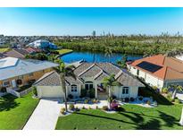 Beautiful home with a tile roof, lush landscaping, and waterfront views at 1368 Grebe Dr, Punta Gorda, FL 33950