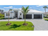 Stunning single-Gathering home featuring a metal roof, impact windows and doors, and a spacious three-car garage at 1631 Casey Key Dr, Punta Gorda, FL 33950