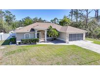 Charming single-story home with a well-maintained lawn, neutral-colored exterior, and attached two-car garage at 4442 Kenvil Dr, North Port, FL 34288