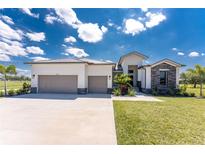 Beautiful single-story home boasts a three-car garage and modern architectural details and landscaped front yard at 16210 Cape Horn Blvd, Punta Gorda, FL 33955