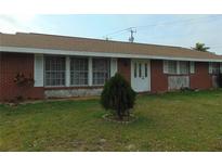 Quaint brick home featuring a well-manicured front yard and decorative shrubbery at 20341 Midway Blvd, Port Charlotte, FL 33952