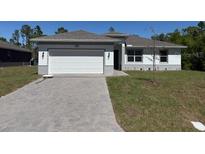 Charming one-story home with a two-car garage and well-maintained lawn, perfect for Gathering living at 23414 Racine Ave, Port Charlotte, FL 33980