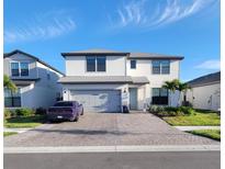 Beautiful two-story home with a brick driveway, two-car garage, and manicured landscaping at 2486 Buckthorn Loop, North Port, FL 34289