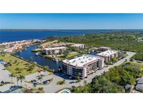 Stunning aerial view of waterfront condos with boat docks, lush landscaping, and beautiful bay views at 25188 Marion Ave # D303, Punta Gorda, FL 33950