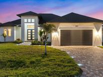 Stunning single-Gathering home featuring a modern design, well-manicured lawn, and charming brick driveway at 260 Long Meadow Ln, Rotonda West, FL 33947