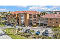 Condominium building with a tile roof and multiple levels with parking at 3322 Purple Martin Dr # 127, Punta Gorda, FL 33950