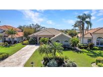 Beautiful single-story home featuring lush landscaping, a tile roof and a paved circular driveway at 3511 Bay Ridge Way, Port Charlotte, FL 33953