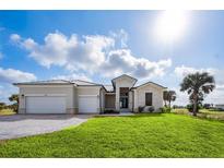 Beautiful new construction home featuring a three-car garage and manicured front lawn at 16440 Cape Horn Blvd, Punta Gorda, FL 33955