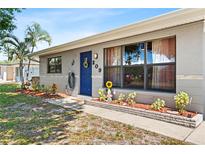 Charming single-story home featuring a well-maintained front yard, a blue front door, and decorative accents at 209 Seminole Nw Blvd, Port Charlotte, FL 33952
