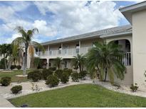 Inviting two-story condo building with lush landscaping, offering a serene and well-maintained living environment at 220 Coldeway Dr # 123, Punta Gorda, FL 33950