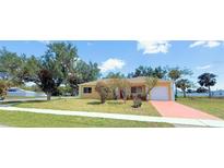 Charming single-story home featuring a lush front yard and a long driveway, under a clear sky at 22299 Catherine Ave, Port Charlotte, FL 33952