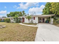 Charming one-story home with a well-manicured lawn, covered porch, and attached carport at 22385 Olean Blvd, Port Charlotte, FL 33952